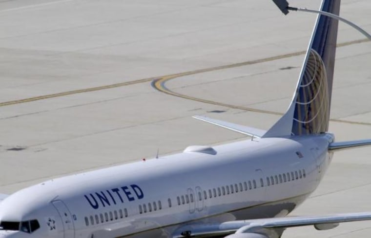 A United Airlines plane with the Continental Airlines logo on its tail, sits at a gate at O'Hare International airport in Chicago