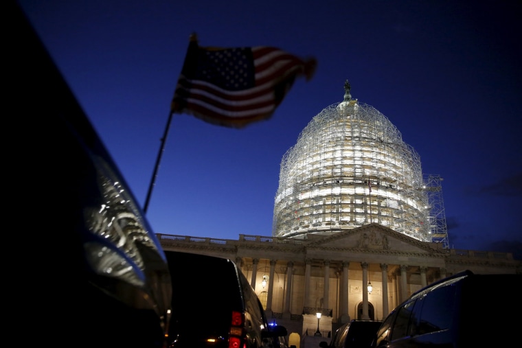 Image: A U.S. flag on a vehicle flutters as the sun sets behind the U.S. Capitol dome in the hours before President Obama delivers the State of the Union address in Washington