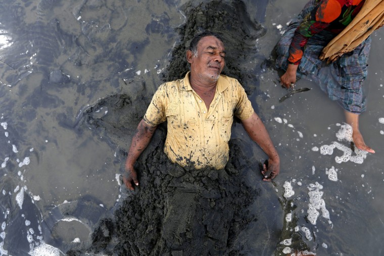 Image: Local people believe that bathing in the in the black sand can prevent from a stroke and hypertension