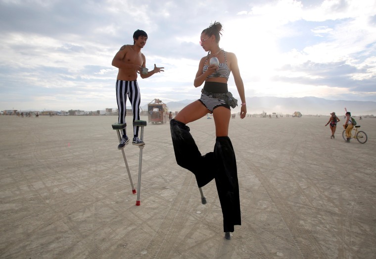 Image: Katapult Sandra and Divine Mustache, using their Playa names, dance on stilts on Monday.