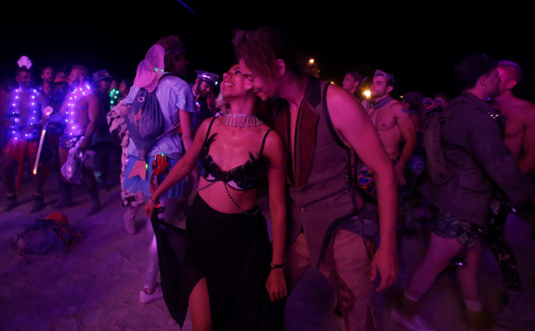 Image: A couple dances as approximately 70,000 people from all over the world gather for the 30th annual Burning Man arts and music festival in the Black Rock Desert of Nevada, U.S.