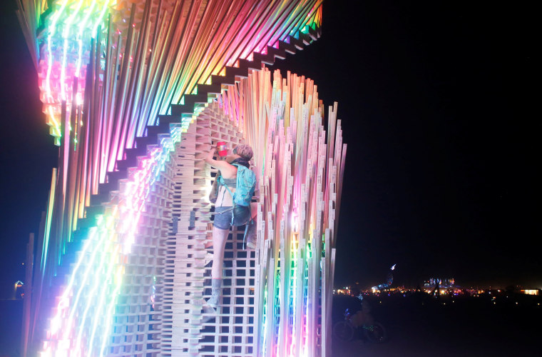 Image: A participant climbs the Tangential Dreams art installation on Wednesday.