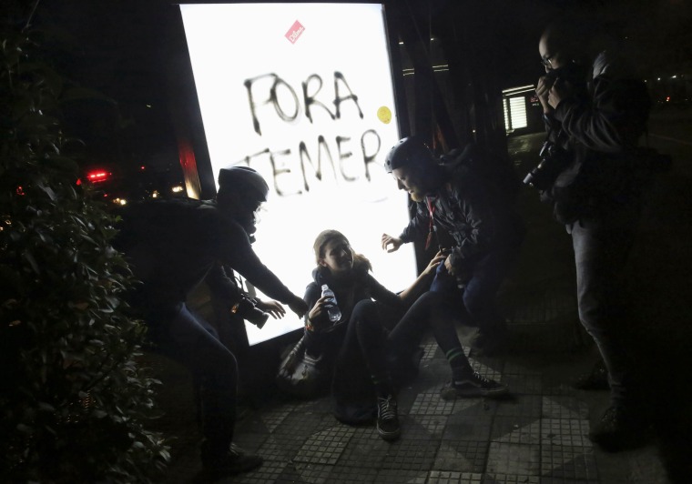 Image: Photographers help a woman who was affected by tear gas during a protest against Brazil's new President Michel Temer after Brazil's Senate removed former Dilma Rousseff in Sao Paulo