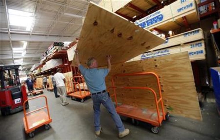 A man loads plywood to board up windows at a Home Depot store in Freeport on Long Island