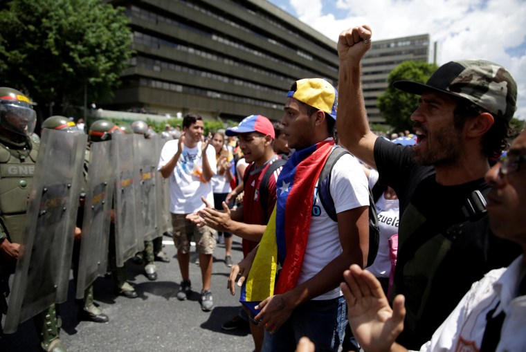 Image: Protesters shout slogans near of riot police during a rally to demand a referendum to remove Venezuela's President Nicolas Maduro in Caracas