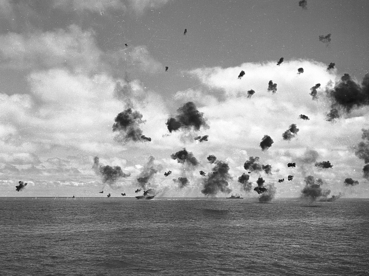 The U.S. aircraft carrier Yorktown, left, and other fighting ships of the U.S. task force in the Pacific, throw up an umbrella of anti-aircraft fire to fight off a squadron of Japanese torpedo planes attacking the carrier during the Battle of Midway, June 4, 1942. A small column of smoke, far left, rises from a Japanese plane that was shot down near the carrier.