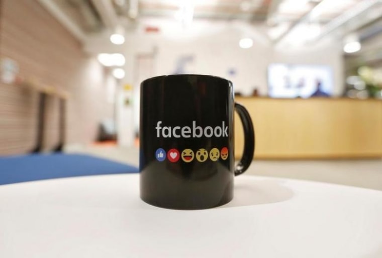 The Facebook logo and emoticons are seen on a coffee mug at the reception of its new office in Mumbai