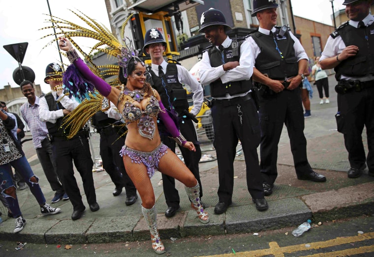 Image: Police look as a performer dances during the Notting Hill Carnival in London