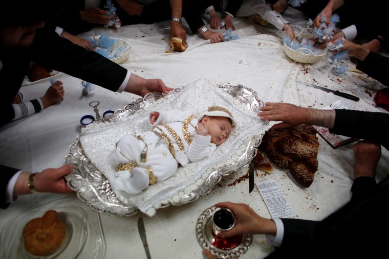 Image: The great-grandson of the spiritual leader of the ultra-Orthodox Jewish Hassidic Lelover dynasty lies on a table during a religious ceremony in Jerusalem