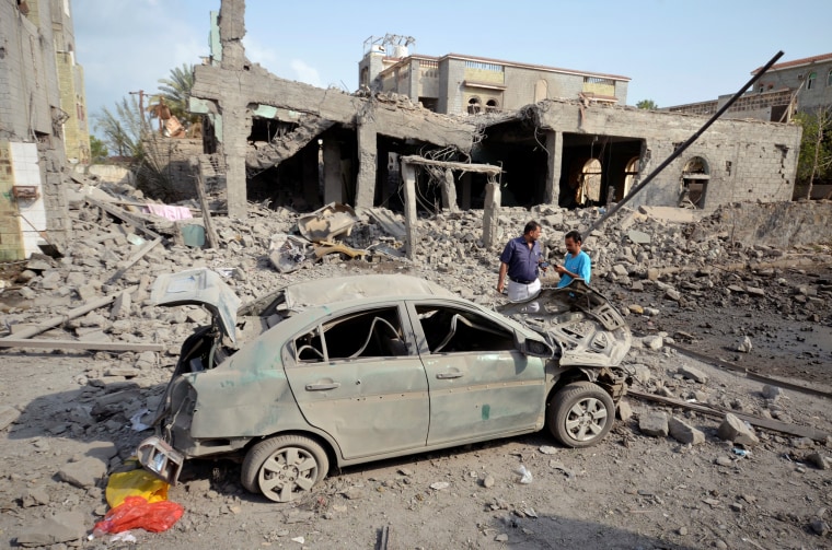 Image: People stand at the site of a Saudi-led air strike in the Red Sea port city of Houdieda, Yemen