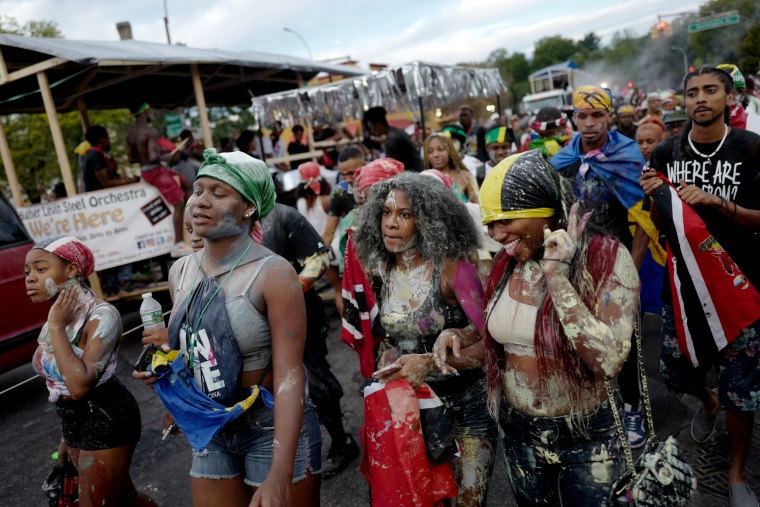 Image: A woman gestures at friends while marching in J'Ouvert, ahead of the annual West Indian-American Carnival Day Parade in Brooklyn