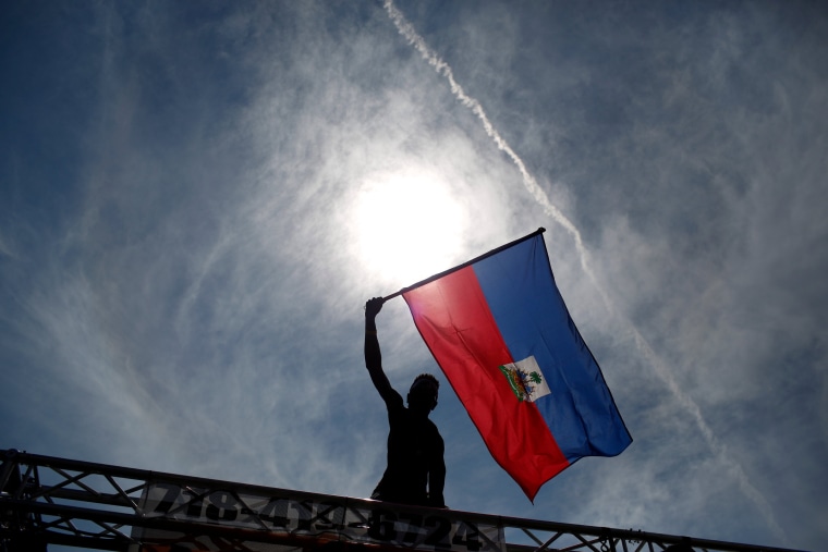 Image: A participant waves a flag during the West Indian Day Parade in the Brooklyn borough of New York