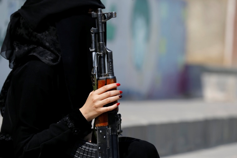 Image: Woman loyal to the Houthi movement holds a rifle as she takes part in a parade to show support to the movement in Sanaa, Yemen