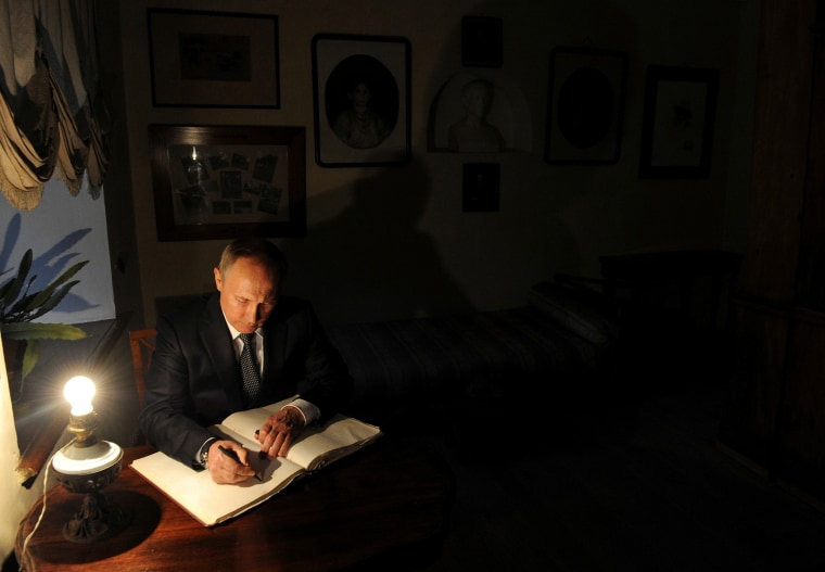 Image: Russian President Putin signs a visitors' book at Russian writer Leo Tolstoy estate museum in Yasnaya Polyana outside Tula