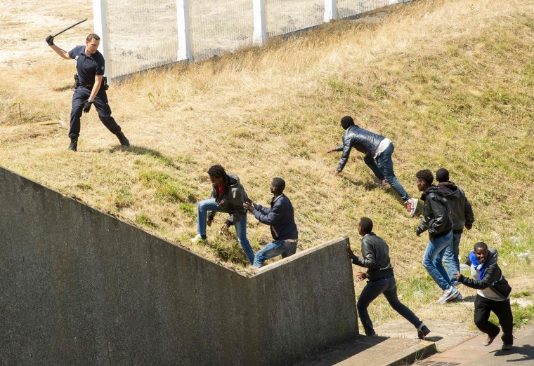 Image: French anti-riot police try to prevent illegal migrants in Calais, France