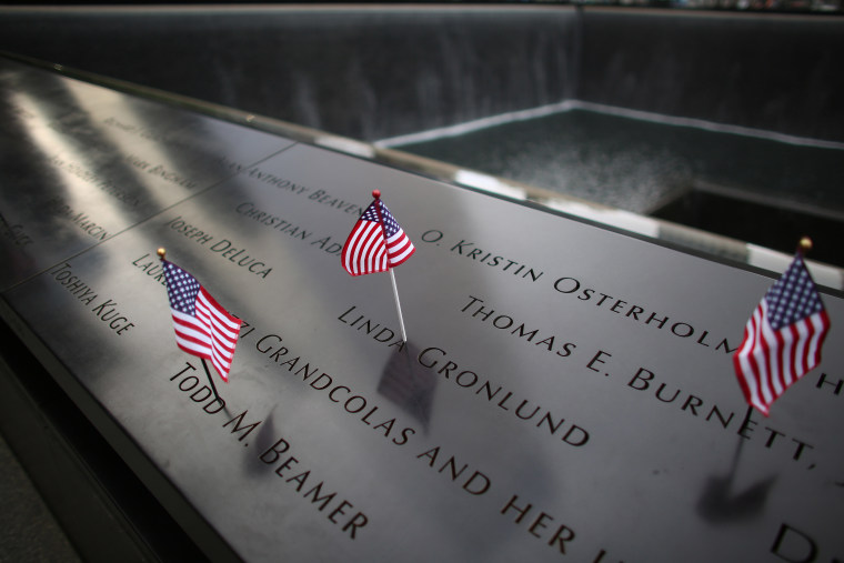 American flags are placed on inscribed names along the edge of the South Tower Memorial during memorial observances on the 13th anniversary of the Sept. 11 terror attacks on the World Trade Center in New York, Thursday, Sept. 11, 2014.