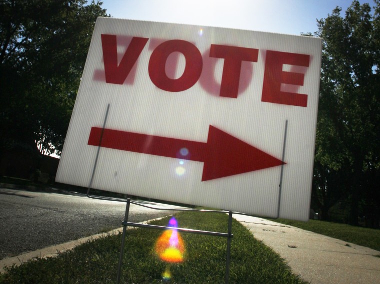 In this Tuesday, Aug. 3, 2010 file photo, the sun shines behind a voting sign outside a polling location in Lawrence, Kan.