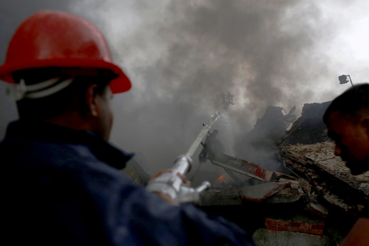 Image: Firefighters extinguish a fire at a garment packaging factory outside Dhaka