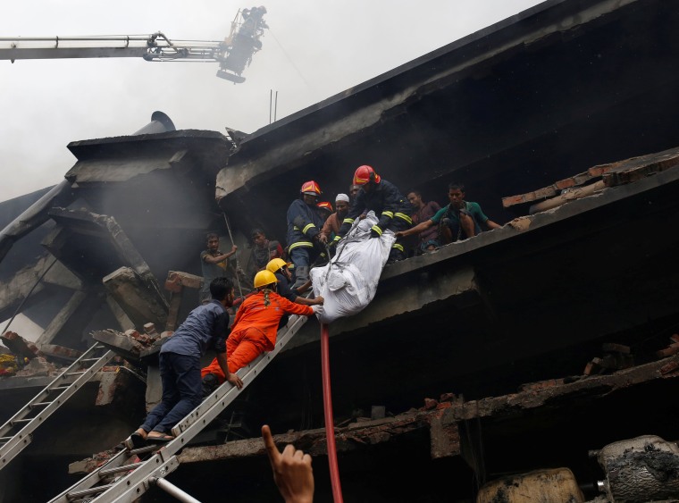Image: Firefighters remove a dead body at a food and cigarette packaging factory after fire broke out outside of Dhaka  Dhaka