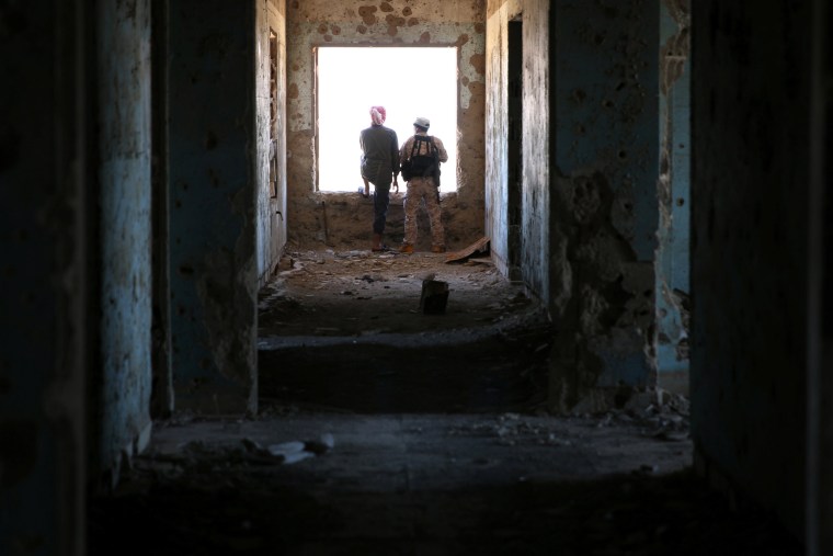 Image: Rebel fighters stand in a damaged building in Quneitra countryside