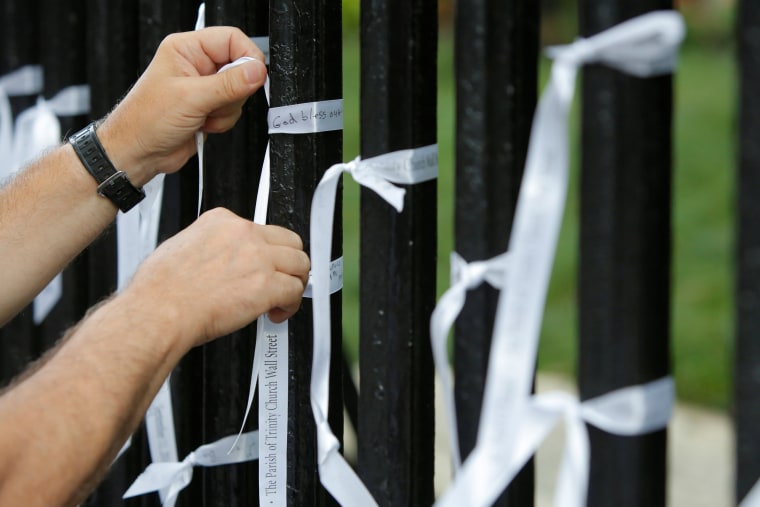 Image: A man ties a memorial ribbon to the exterior wall of St. Paul's Chapel on the morning of the 15th anniversary of the 9/11 attacks in Manhattan, New York