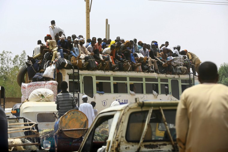 Image: People ride on a bus as they return to their families ahead of the Eid al-Adha festival in Khartoum