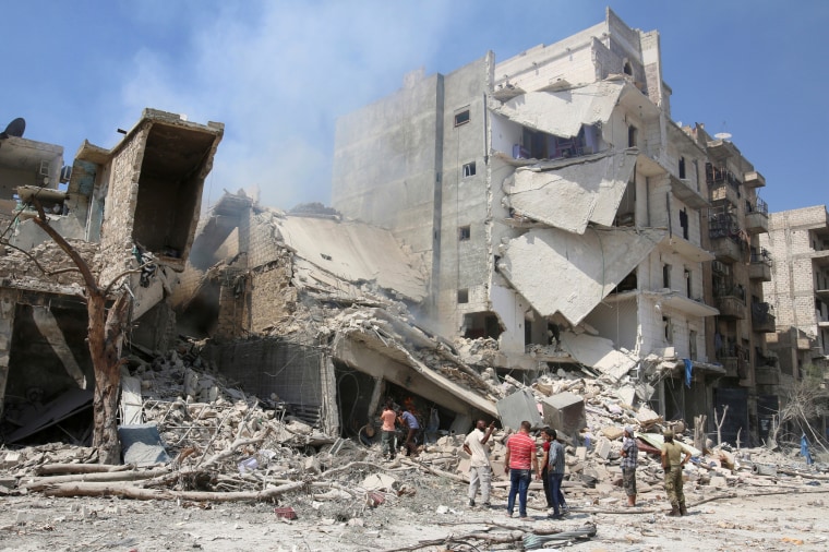 Image: A file photo shows men inspecting a damaged site after double airstrikes on the rebel held Bab al-Nairab neighborhood of Aleppo