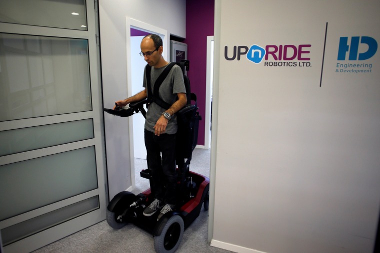 Image: An employee stands on a wheelchair developed by Israeli company UPnRIDE Robotics, that enables paralysed people with limited function in their arms to stand upright, during a demonstration at their offices in Yoqneam