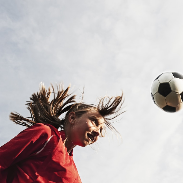 Young soccer player bouncing ball off head