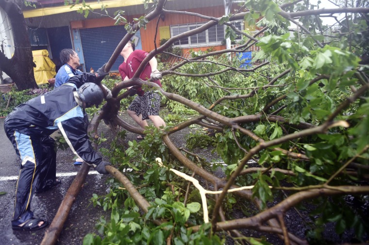 Image: Local residents help clear fallen trees from the streets
