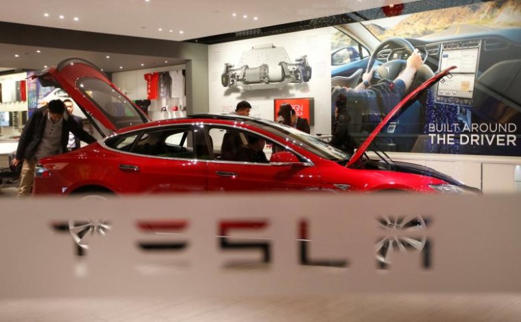 A man looks around Tesla Motors' Model S P85 at its showroom in Beijing