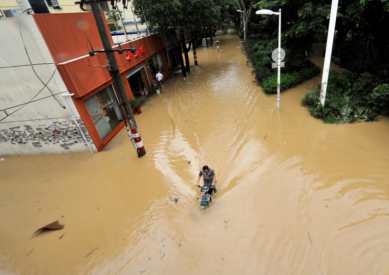 Image: A man rides through a flooded street after Typhoon Meranti made landfall on southeastern China, in Fuzhou