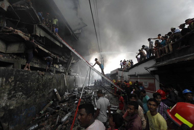 Image: Firefighters attempt to extinguish a fire at a garment packaging factory in the Tongi industrial area