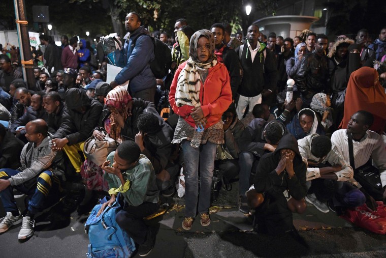 Image: Migrants are evacuated from a makeshift migrant camp in Paris