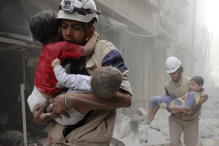 Image: Members of the Civil Defence rescue children after what activists said was an air strike by forces loyal to Syria's President Assad in al-Shaar neighbourhood of Aleppo