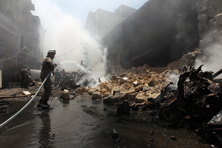 Image: A Civil Defence member tries to put out a fire after an airstrike on al-Jalaa street in the rebel held city of Idlib
