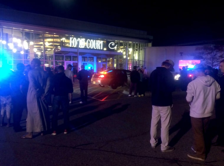 Image: People stand outside the scene of a stabbing at the Crossroads Center mall in St. Cloud, Minnesota