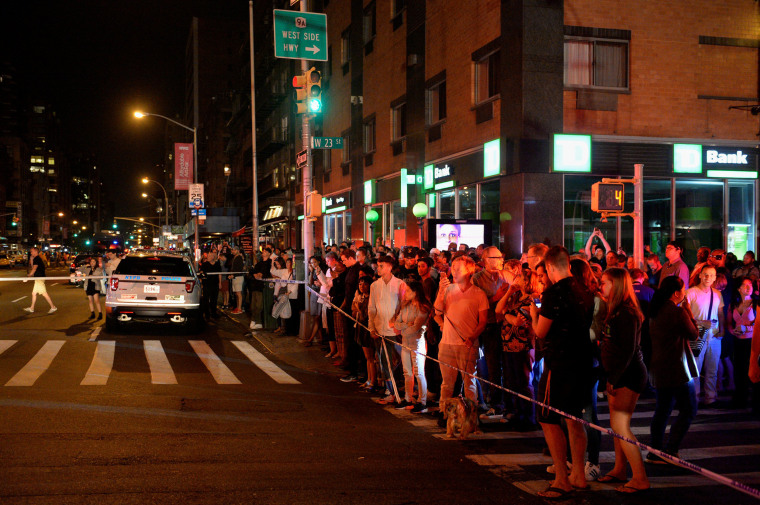 Image: Onlookers stand behind a police cordon near the site of an explosion in Manhattan, New York