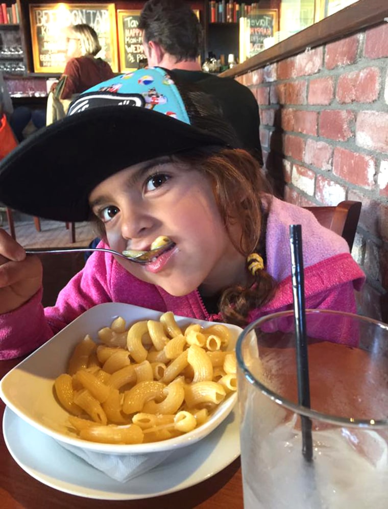 Ella Scott eating a big bowl of pasta while out to eat with her dad.