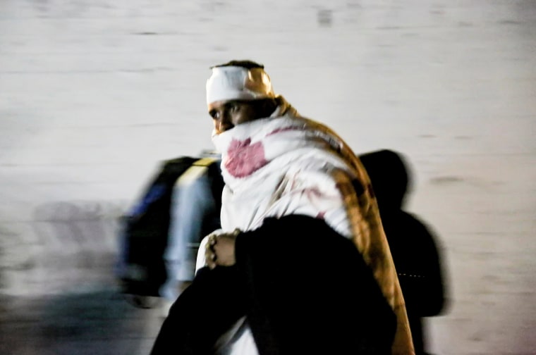 Image: A migrant is covered with a blanket after a fire at the Moria migrant camp on the island of Lesbos