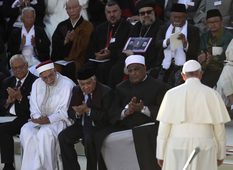 Image: Representatives of different religions applaud after Pope Francis delivered his speech during the closing event of an inter-religious prayer gathering