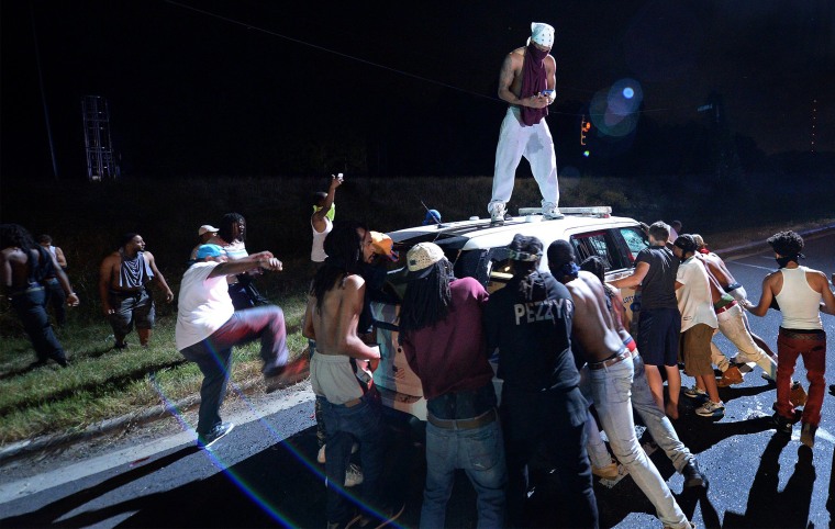 Image: Protesters surround a police vehicle in Charlotte