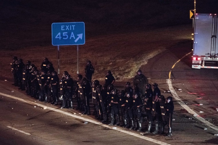 Image: Police officers take position at an onramp on I-85 during protests
