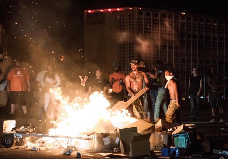 Image: People set cargo from tractor trailers on a fire on I-85 during protests