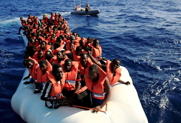 Image: An overcrowded dinghy with migrants from different African countries is followed by members of the German NGO Jugend Rettet as they approach the Iuventa vessel during a rescue operation in the Mediterranean Sea