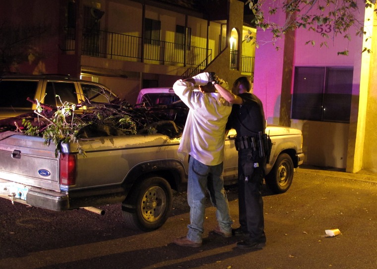 An Albuquerque officer frisks a man after he and two others were seen driving into an apartment known for drug activity in 2012.