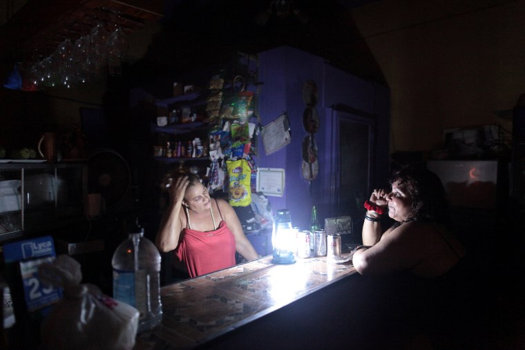 Image: Flor Dalisa Contreras talks with Virginia Rivas at a coffee shop during a power outage that affected several areas in the country, in San Juan