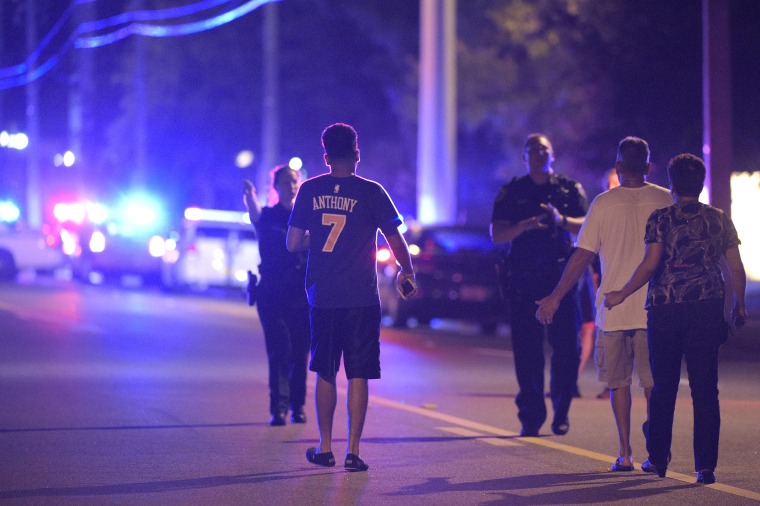 In this photo taken June 12, 2016, Orlando Police officers direct family members away from a shooting involving multiple fatalities at the Pulse Orlando nightclub in Orlando, Fla.