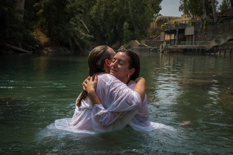 Image: U.S. veterans Katherine Ragazzino and Jackie Ann Kirkwood hug after being baptized in the Jordan River in northern Israel.