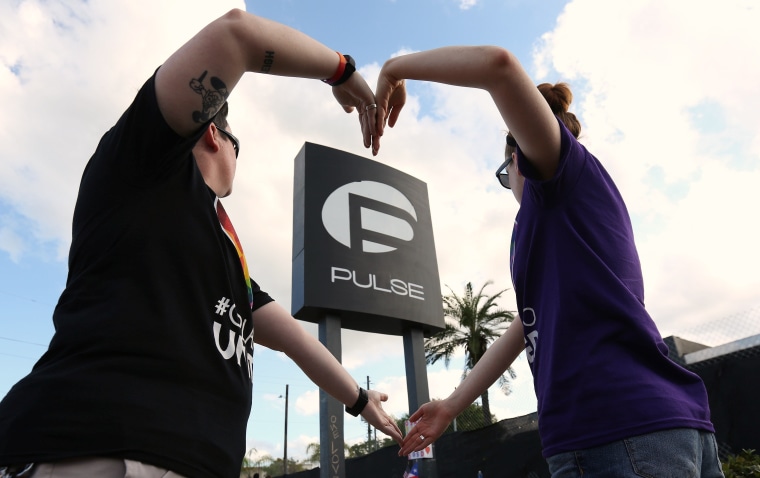 Heather Raleigh (L) and Paige Metelka make a heart shape as they pose during a photo shoot outside Pulse nightclub following the mass shooting last week in Orlando, Florida, U.S., June 21, 2016.